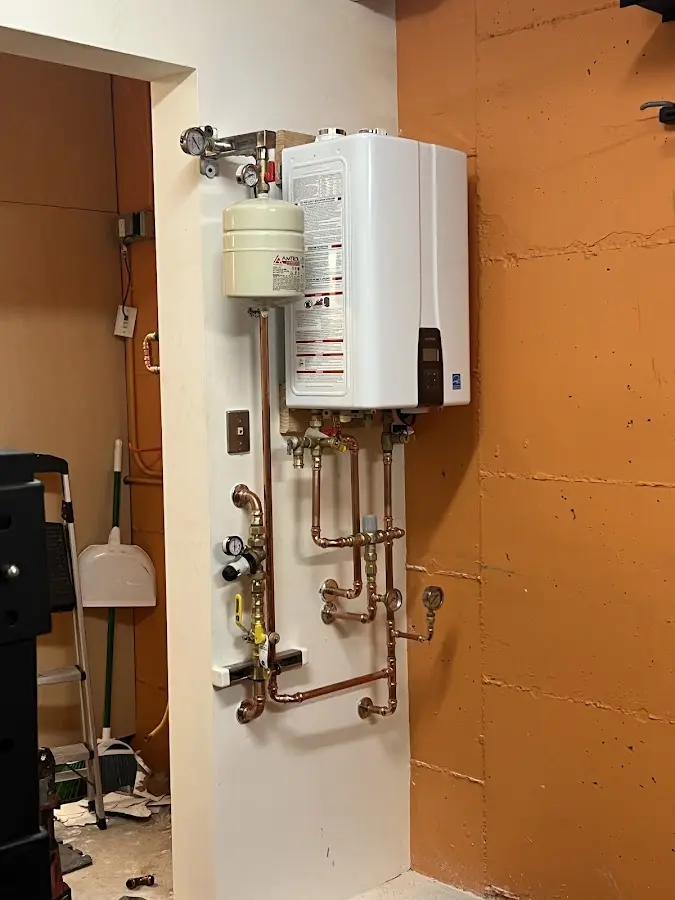 Plumbing technician inspecting water heater connections in Nicholasville
